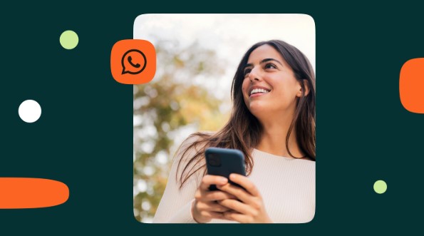 Imagem de uma mulher sorrindo, com suéter branco, celular na mão e um ícone do WhatsApp.