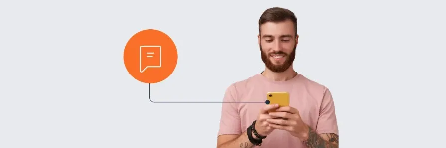 Homem com barba segurando smartphone amarelo e sorrindo, vestindo camiseta rosa-claro. À esquerda, um círculo laranja com ícone branco que simboliza conversa. Linha curva azul conecta o círculo ao ponto próximo à tela do celular. Fundo cinza-claro.