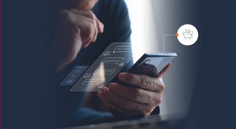 Una persona sostiene un teléfono móvil en la mano con la pantalla proyectada, mostrando una conversación con un chatbot.