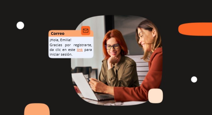 Dos mujeres trabajando juntas frente a una laptop, una de ellas sonriendo y señalando la pantalla; un globo de chat naranja y un icono de correo flotan sobre la imagen.