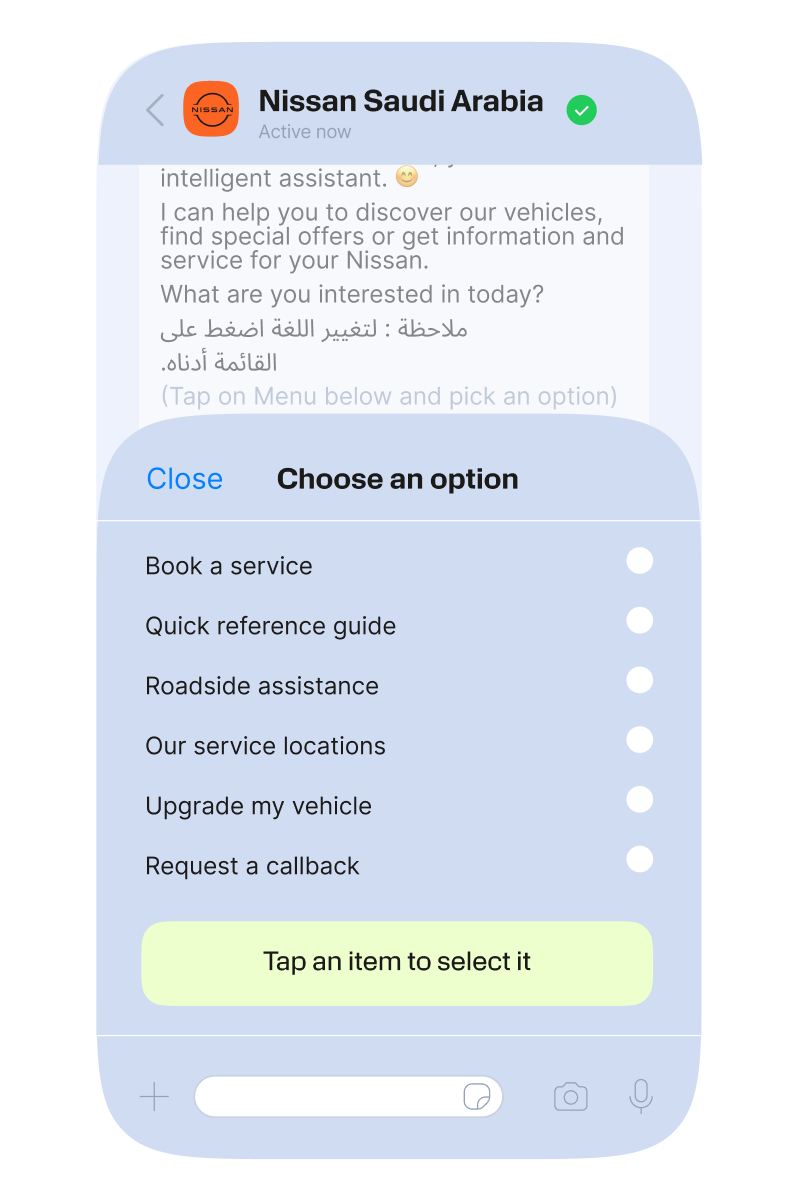 A smartphone screen shows a WhatsApp chat with ‘Nissan Saudi Arabia’ at the top, including a green verified check mark. A light-blue in-chat menu panel is open, titled ‘Choose an option’ with a ‘Close’ link on the left. The menu lists six tappable options in black text, each with a circular icon to the right: ‘Book a service,’ ‘Quick reference guide,’ ‘Roadside assistance,’ ‘Our service locations,’ ‘Upgrade my vehicle,’ and ‘Request a callback.’ At the bottom of the panel, a pale yellow button reads ‘Tap an item to select it.’