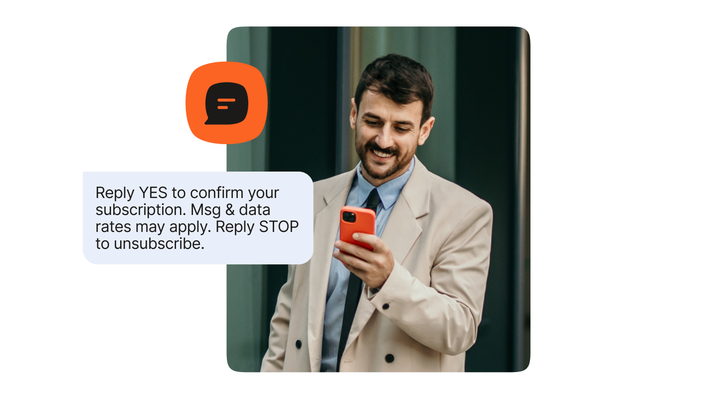 Man in a light-colored coat looking at his smartphone beside a sample SMS message that reads: “Reply YES to confirm your subscription. Msg & data rates may apply. Reply STOP to unsubscribe.” An orange chat icon appears above the message.