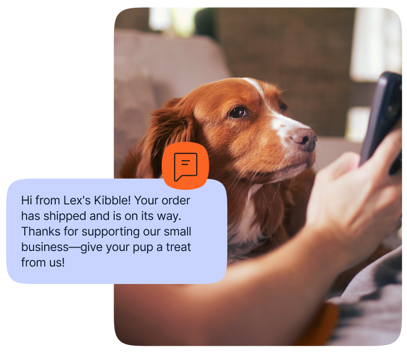 A dog owner sitting next to a dog and reading a text message that says: Hi from Lex's Kibble! Your order has shipped and is on its way. Thanks for supporting out small business-give your pup a treat from us!