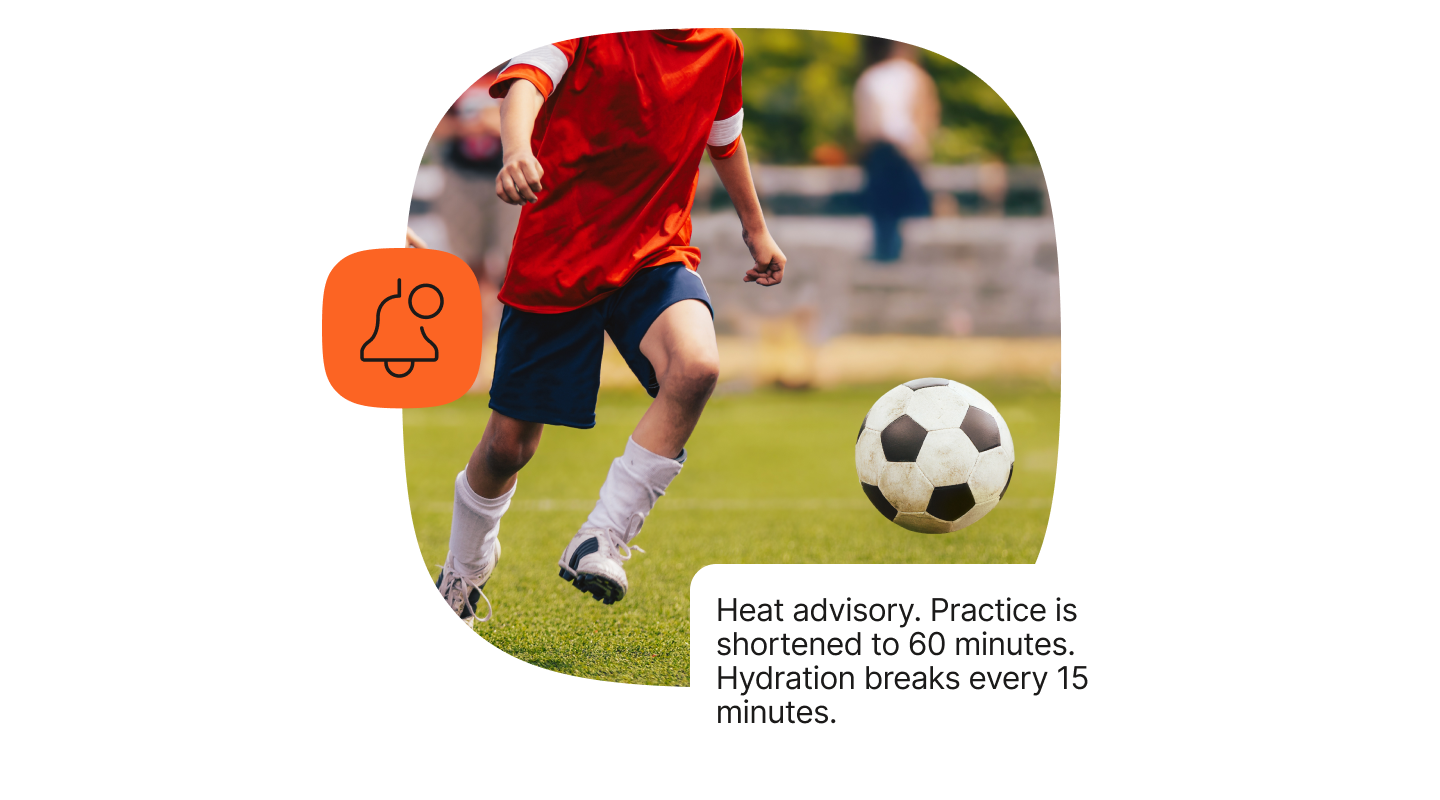 A young soccer player wearing a red jersey, navy blue shorts, white knee-high socks, and soccer cleats is actively running on a green grass field. The scene captures the player's leg muscles and lower torso as the soccer ball rolls ahead on the field. A bulletin notification icon appears in orange on the left side, accompanied by a text box stating a heat advisory that shortens practice to 60 minutes with hydration breaks every 15 minutes.