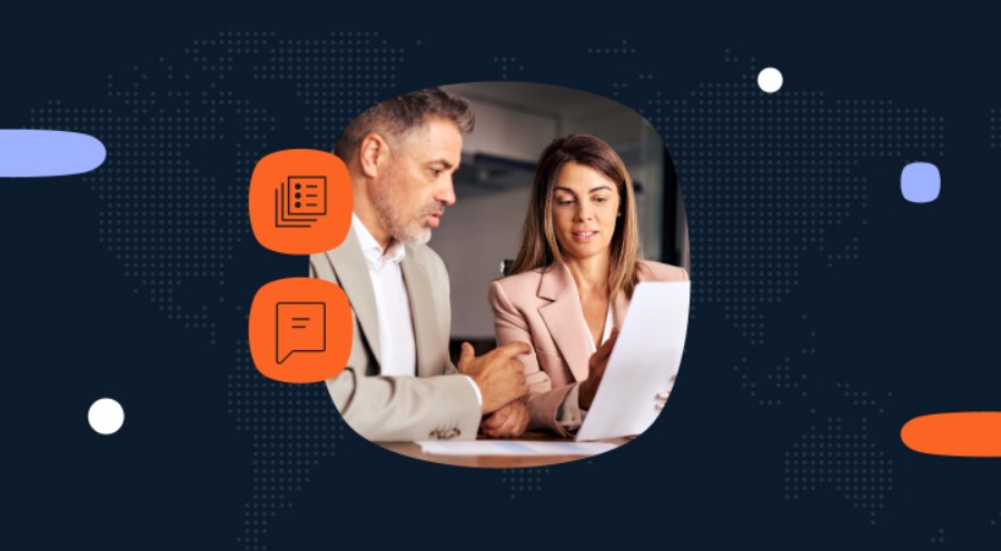 Una mujer y un hombre con ropas formales están sentados con papeles sobre la mesa.