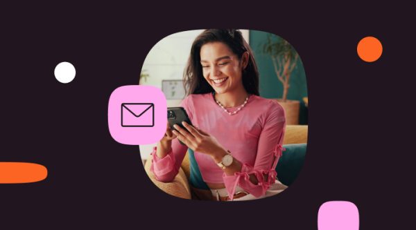 Blog header image showing a woman reading a message on her phone with an email icon, representing modern email marketing in an omnichannel world.