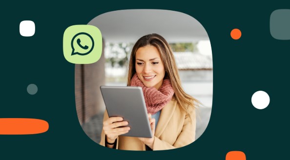 Mujer con tablet en la mano y una sonrisa en el rostro. La imagen tiene el ícono de WhatsApp.