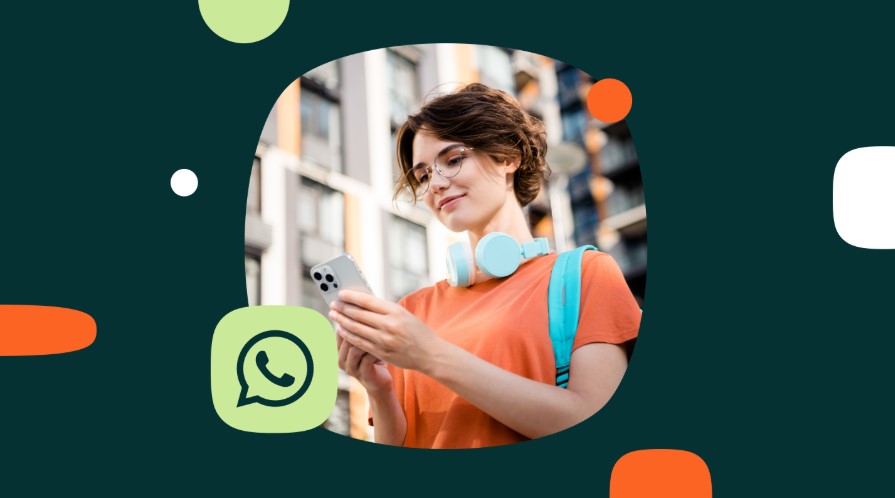 Mujer joven con teléfono en la mano y camiseta naranja.