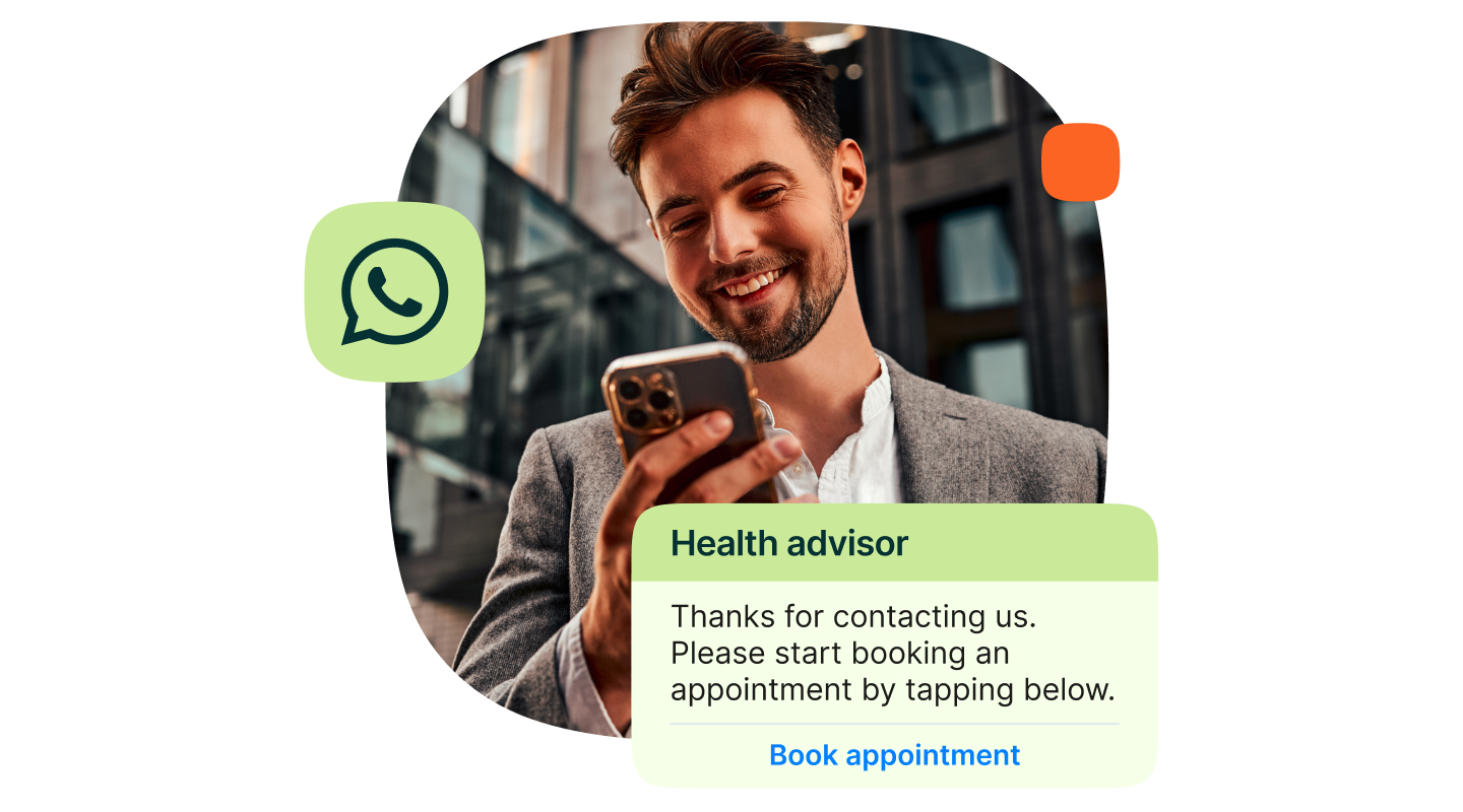 Man smiling while reading a WhatsApp message. The message from “Health advisor” says: “Thanks for contacting us. Please start booking an appointment by tapping below.” A button labeled “Book appointment” appears under the message.