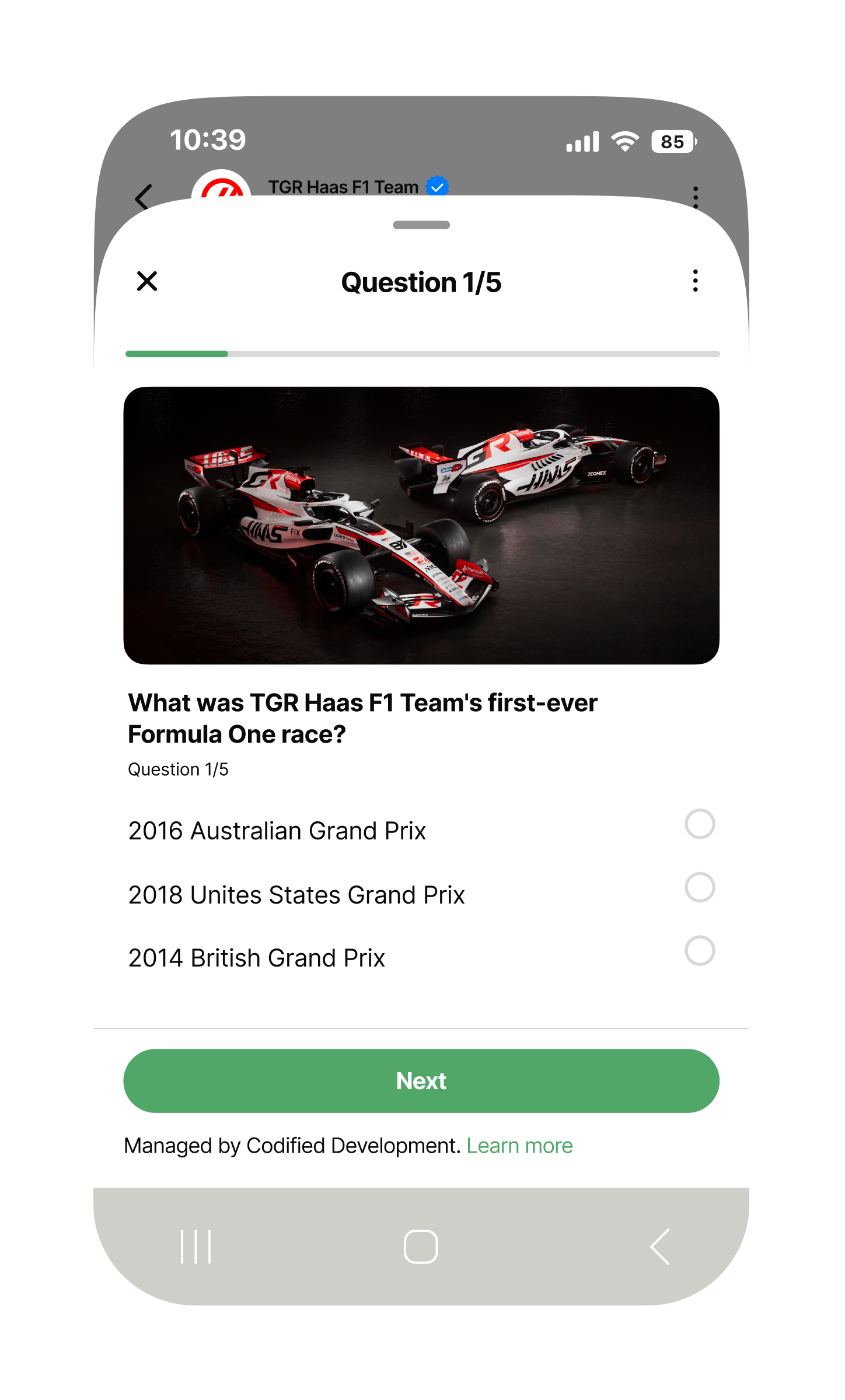 Mobile phone screen showing a WhatsApp-style quiz titled ‘Question 1/5’. A progress bar near the top is slightly filled. Below it is an action photo of a TGR Haas F1 car racing on track. The multiple-choice question reads: ‘What was TGR Haas F1 Team’s first-ever Formula One race?’ with three answer options listed vertically: ‘2016 Australian Grand Prix,’ ‘2018 United States Grand Prix,’ and ‘2014 British Grand Prix,’ each with an empty radio button. At the bottom is a large green ‘Next’ button and a note stating the quiz is managed by Codified Development.