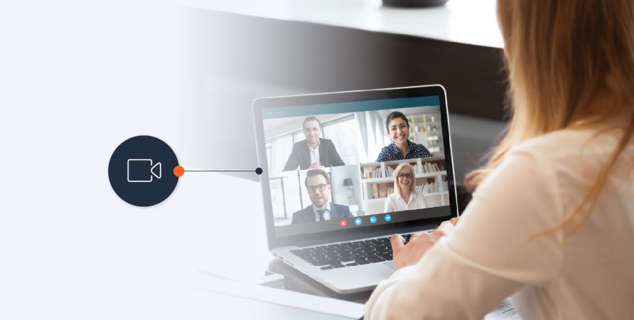 Mujer con computadora en una reunión con más cuatro personas.