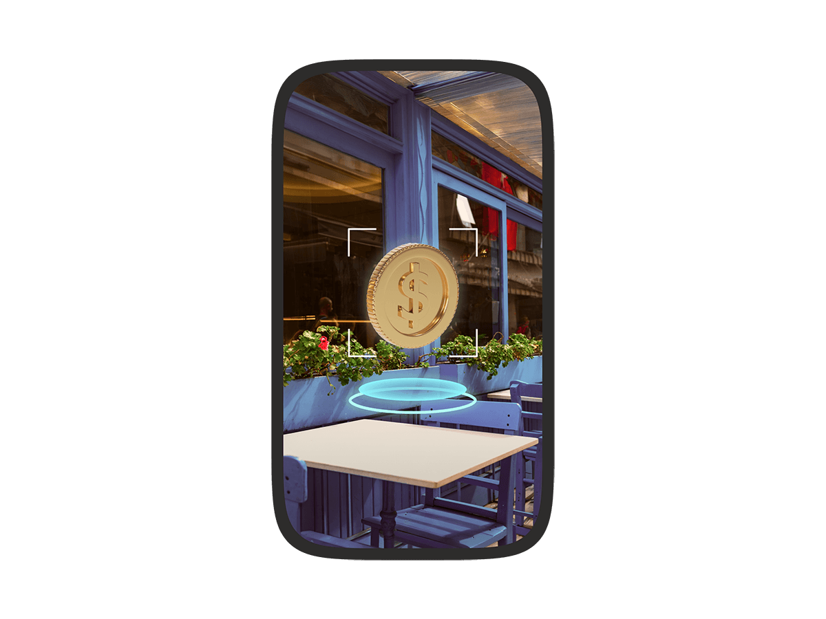 A phone screen showing an augmented reality view of a café with a virtual gold dollar coin floating above a table, highlighted by a targeting frame.