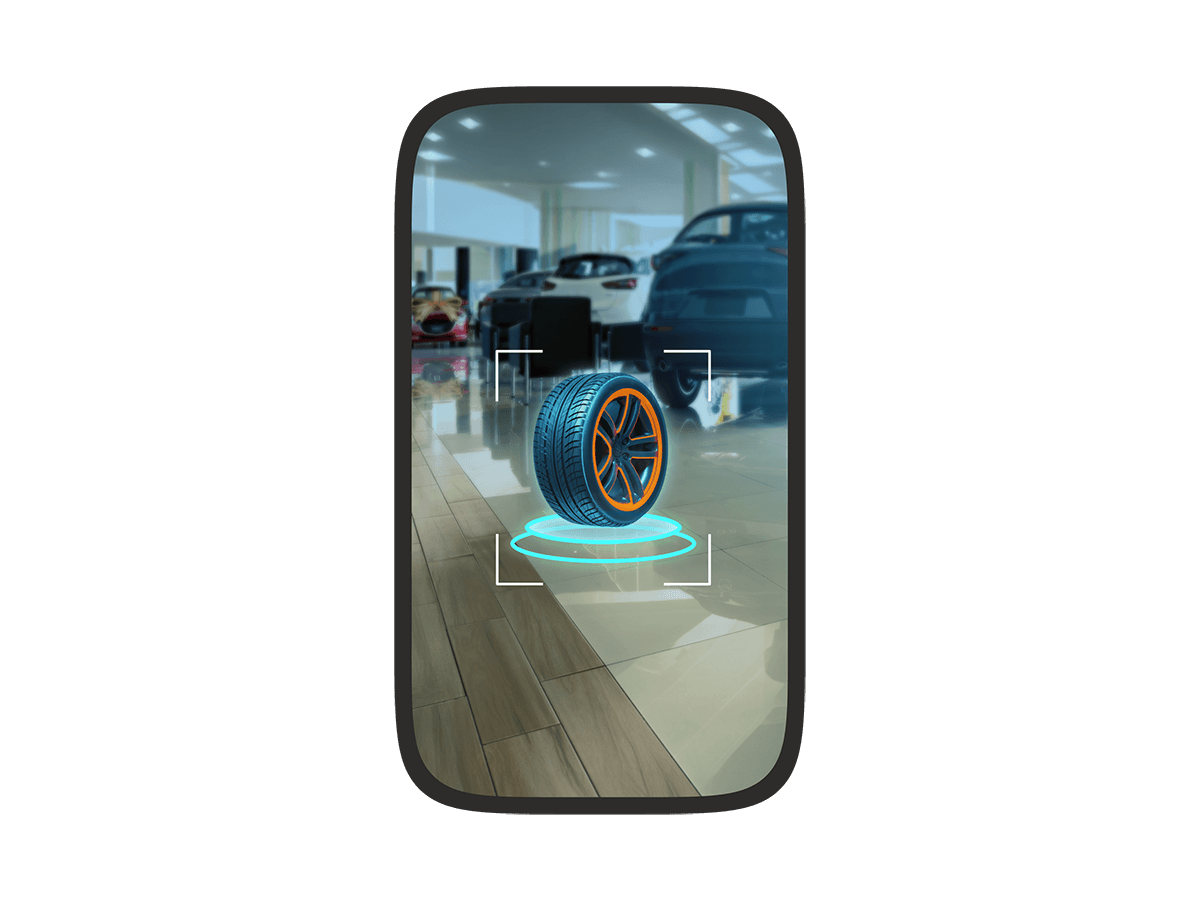 A phone screen showing an augmented reality view of a car showroom with a virtual tire floating in the center, highlighted by a targeting frame.