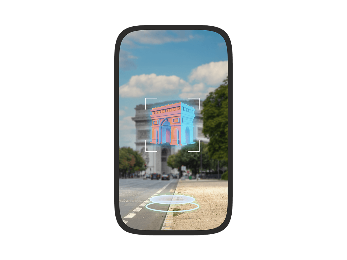 A phone screen showing an augmented reality view of a Paris street with a colorful 3D model of the Arc de Triomphe floating in the foreground, highlighted by a targeting frame.