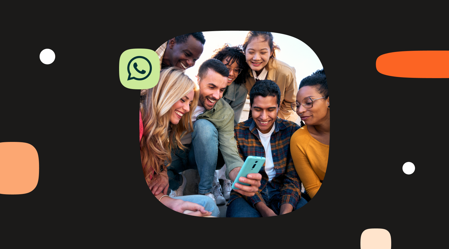 Dark background with a rounded central photo of six diverse young adults smiling and gathered closely while looking at a smartphone. A green WhatsApp logo icon appears to the left of the photo. The background includes abstract design elements such as orange rounded shapes and small white dots, creating a modern tech-themed layout. No visible text.