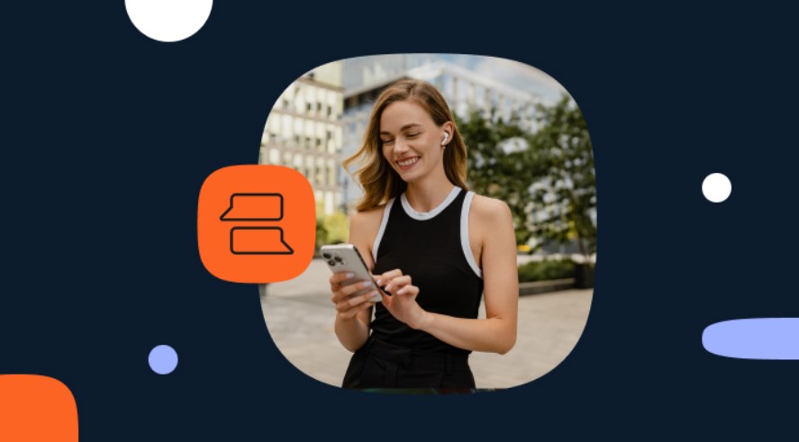 Imagem de uma mulher sorrindo com um celular na mão.