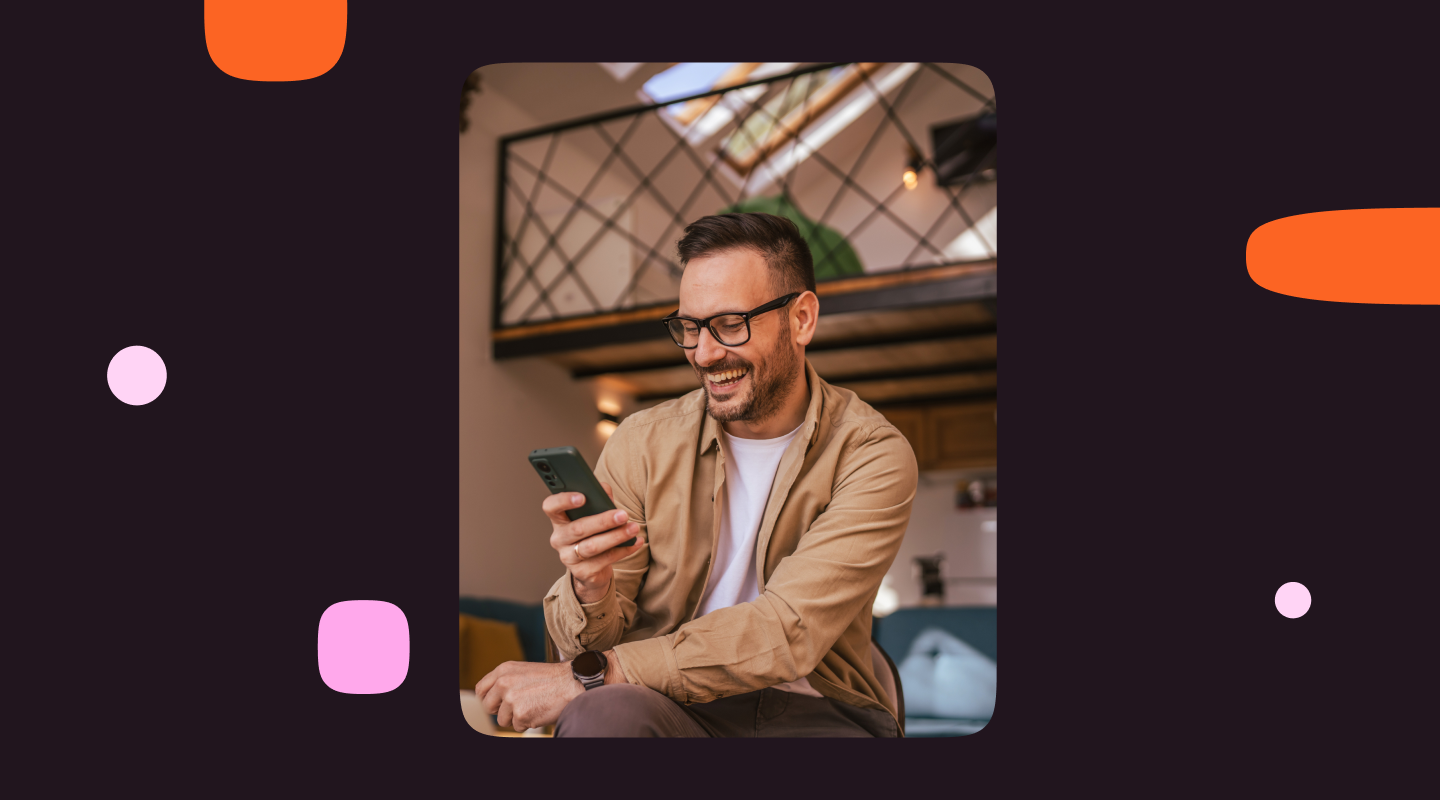 Man wearing glasses smiles while using his smartphone, illustrating a positive customer experience with conversational AI on mobile.