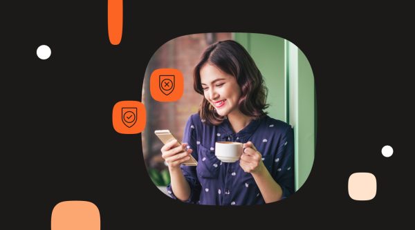 Woman smiling while checking her phone, with icons showing an unverified shield and a verified shield representing trusted RCS messages.