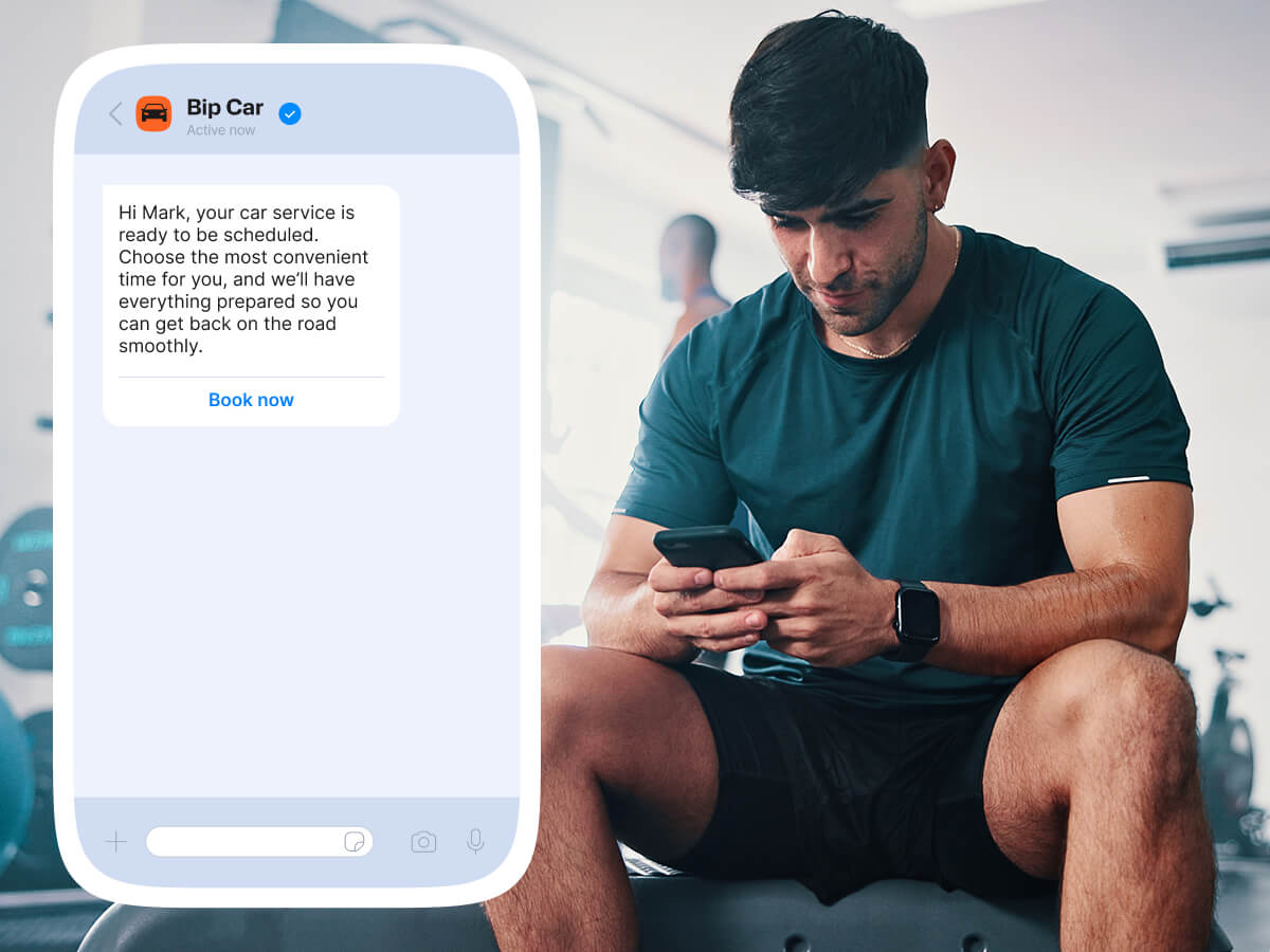Man checking car service booking message on smartphone while sitting at the gym