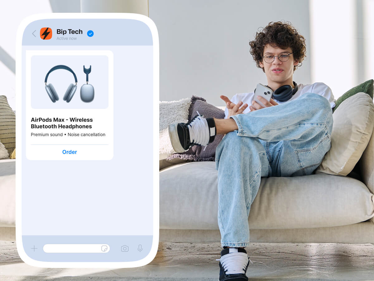 Young man viewing wireless headphones product message on smartphone while sitting on couch